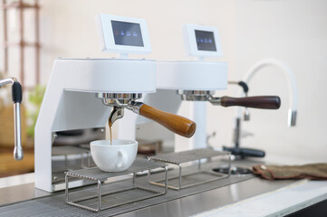 coffee machine making black coffee and pouring into a cup at cafe