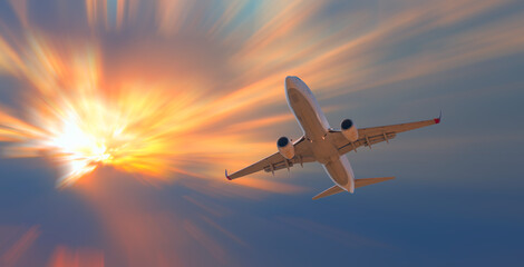 Naklejka na ściany i meble Airplane in the sky at sunset