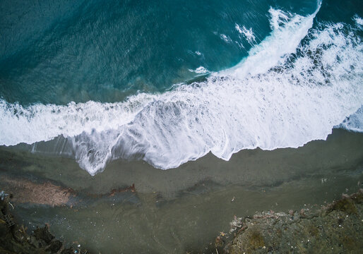 drone shot of waves breaking on the beach from above, greece, cr