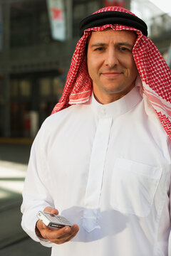 Middle Eastern man in traditional clothing with cell phone