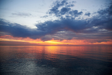 Fototapeta premium Beautiful cloudy sky at dawn, calm sea water.