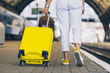 Fototapeta premium woman with yellow bag at railway station