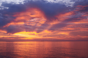 Beautiful cloudy sky at dawn, calm sea water.