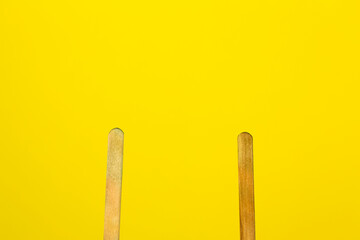 Frozen popsicle sticks on a yellow background