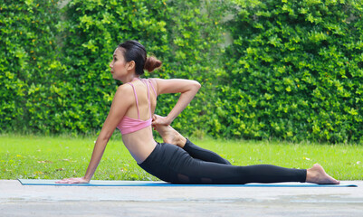 Portrait Asian women exercising by practicing yoga in garden. concept  exercise for health and relaxation.  woman happily doing yoga on park