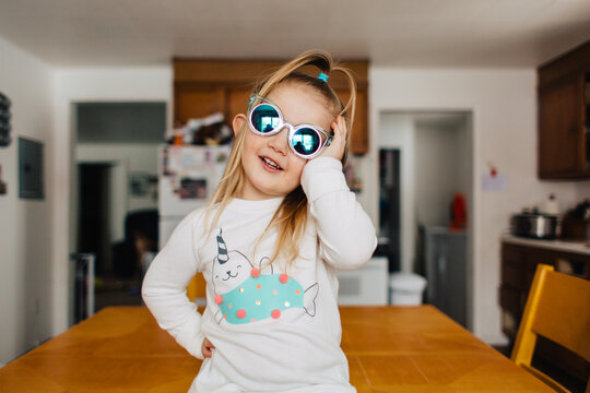 Cute toddler girl in narwhal shirt and funky sunglasses.