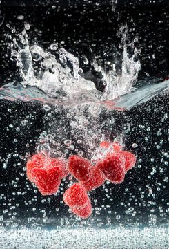 Raspberries Spashing into Bubble Water