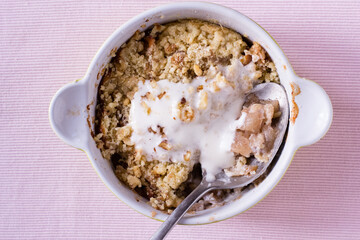 Apple crumble with ice cream on pink textile