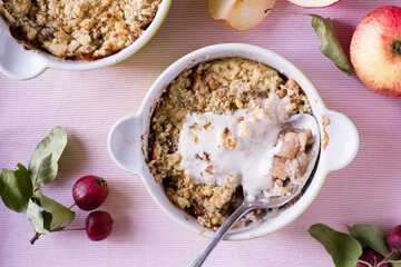Apple crumble with ice cream on pink textile
