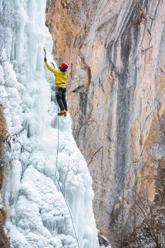 Male alpinist ice climbing