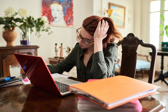 Beautiful red-haired woman working at vintage desk.