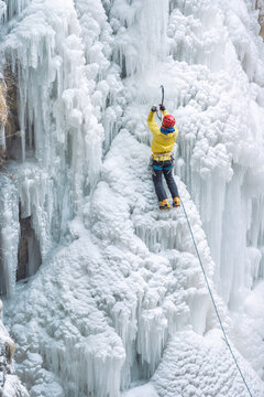 Man ice climbing on frozen waterfall