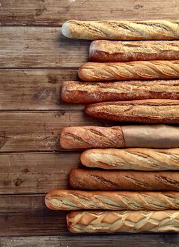 Loaves of bread lined on worn wood surface