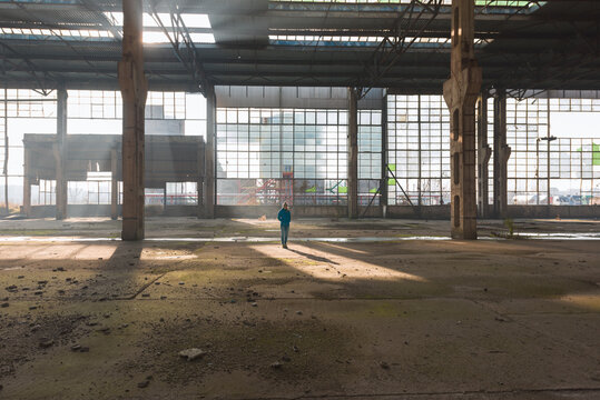 Woman standing still in abandoned warehouse