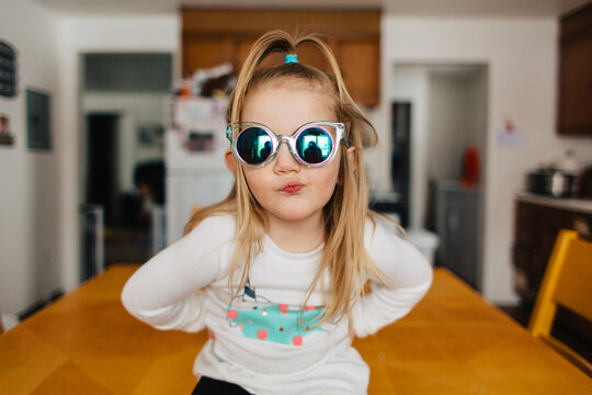 Cute toddler girl in narwhal shirt and funky sunglasses.