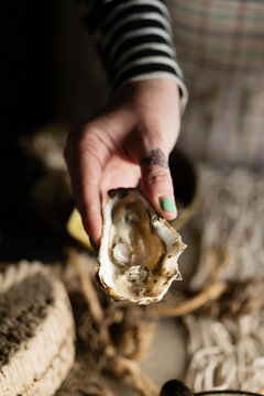 Woman preparing oysters for eating.