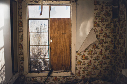 A room in an abandoned building with peeling wallpaper