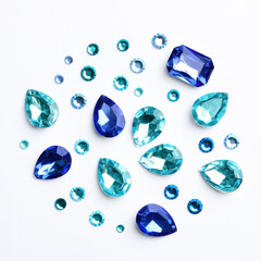 Different beautiful gemstones on white background, top view