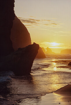 Bandon Beach Oregon at late afternoon sunset in winter, low incoming ebb tide, seastacks