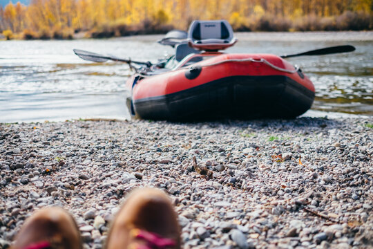 A view of hiking boots and a river raft