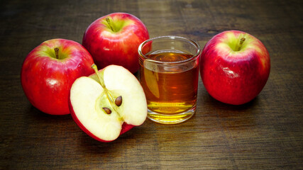 Apple cider vinegar in glass with apples on a wooden background.Selective focus.	