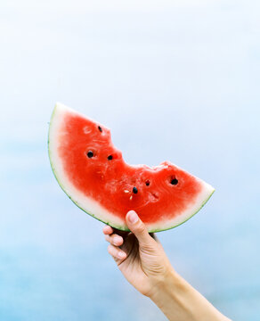 Person holding bite watermelon