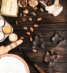 Kitchenware,  almond nuts, flour, eggs, butter,   on wooden background , top view.