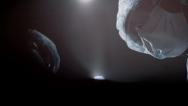From below point of view shot of unrecognizable professional surgeons starting doing surgery for patient