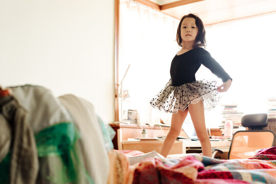 Adorable girl dancing ballet on bed