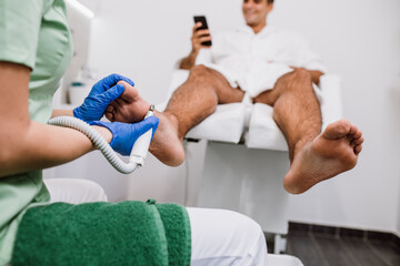 Young man having pedicure treatment in a modern beauty salon.