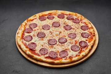 Delicious Italian Pizza pepperoni with mozzarella cheese and salami on dark background