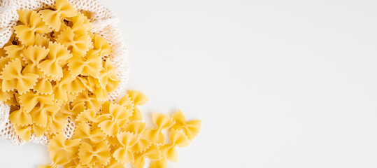 Raw dry uncooked Farfalle pasta spaghetti noodle on white bowl wooden background for basil tomato pesto sauce Homemade Italian food organic whole wheat vegan spaghetti for a healthy meal