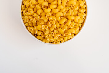 Raw dry uncooked Mini pipe rigate pasta spaghetti noodle on white bowl wooden background for basil tomato pesto sauce Homemade Italian food organic whole wheat vegan spaghetti for a healthy meal