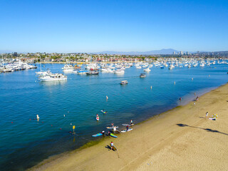 a gorgeous shot of the deep blue ocean water and the boats sailing in the harbor and the beach in...