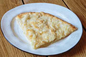 Large piece of pizza with cheese. Hot tortilla with cheese, Khachapuri, Caucasian kitchen.