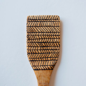 Wood burned bamboo wooden spoons on white background.