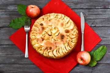 Apple Pie on a wooden background. Festive Delicious Food and Fresh apples on red napkin, Yummy pie....