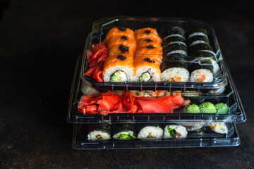 sushi rolls salmon fish flying fish roe vegetables ginger wasabi rice and nori on the table top view place copy space for text food background rustic