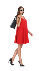 Young woman wearing stylish red dress with elegant bag on white background