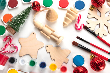 Wooden Christmas decorations for painting, brushes, paints on a white background. Christmas and New...