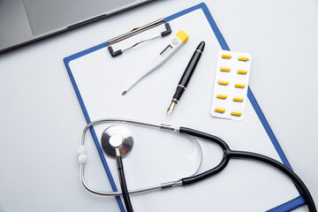 Medical pills,thermometer and stethoscope on the medical claim form