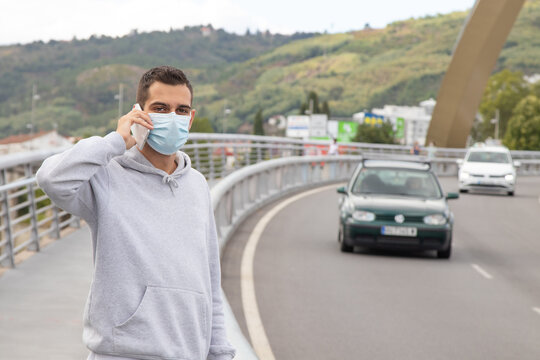 man with a mask on the road calling by phone