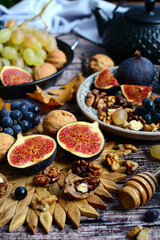 Figs, grapes, walnuts on a wooden background, close-up.