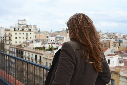 Girl with windy hair on balcony.