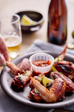 Cooked chicken wings on a plate with a sauce.