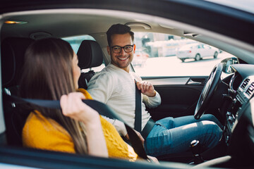 Husband and his pregnant wife driving in car.