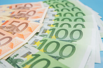 Financial background. euro banknotes on blue. 100 and 50 euros