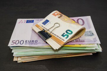 money stack on black wooden background. Euro banknotes. Much money.