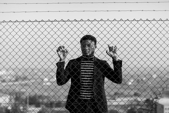 African man behind an iron grid