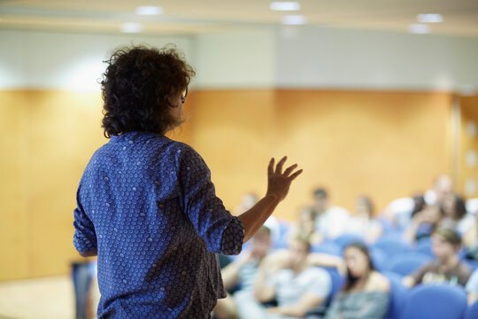 Female speaker delivers a public speech in an auditorium